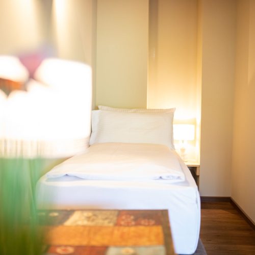 Einzelbett mit weißen Kissen in Ferienwohnung in Garmisch-Partenkirchen