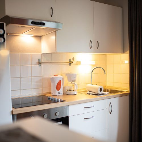 Küche mit weißen Schränken in Ferienwohnung in Garmisch-Partenkirchen