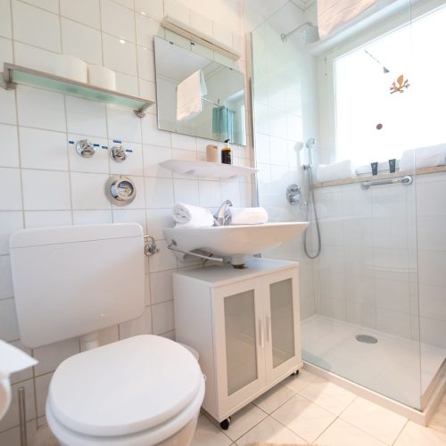 Badezimmer mit weißen Fliesen in Ferienwohnung in Garmisch-Partenkirchen