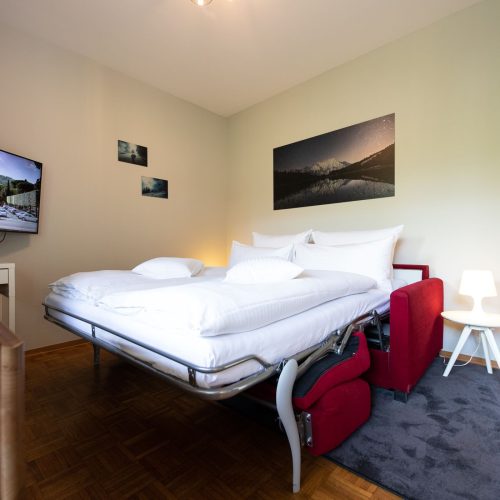 Schlafsofa mit Nachttisch in Ferienwohnung in Garmisch-Partenkirchen