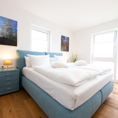 Doppelbett mit Fenstern in Ferienwohnung in Garmisch-Partenkirchen