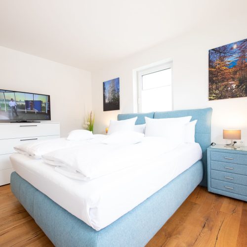 Doppelbett mit Bildern in Ferienwohnung in Garmisch-Partenkirchen