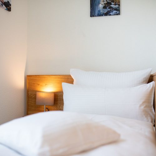 Bett mit einer Nachttischlampe in Ferienwohnung in Garmisch-Partenkirchen