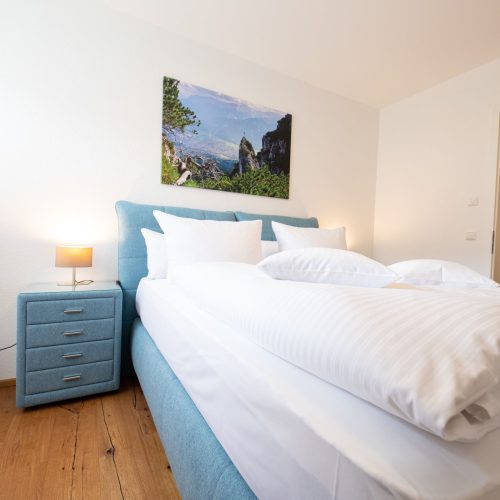 Bett mit einem passenden Nachtschrank in Ferienwohnung in Garmisch-Partenkirchen