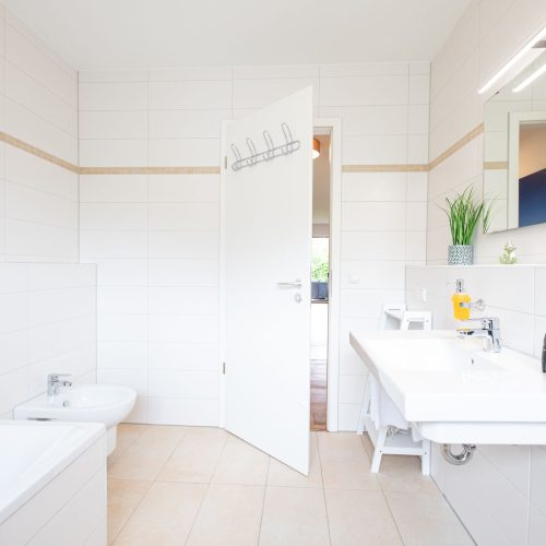 geräumiges Badezimmer mit einem großen Spiegel in Ferienwohnung in Garmisch-Partenkirchen