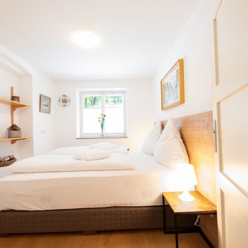 Schlafzimmer mit Holztönen in Ferienwohnung in Garmisch-Partenkirchen