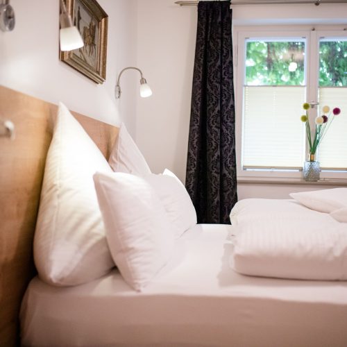 Bett mit einem Holz farbenen Kopfteil in Ferienwohnung in Garmisch-Partenkirchen