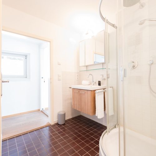 Badezimmer mit dunklen Fliesen in Ferienwohnung in Garmisch-Partenkirchen
