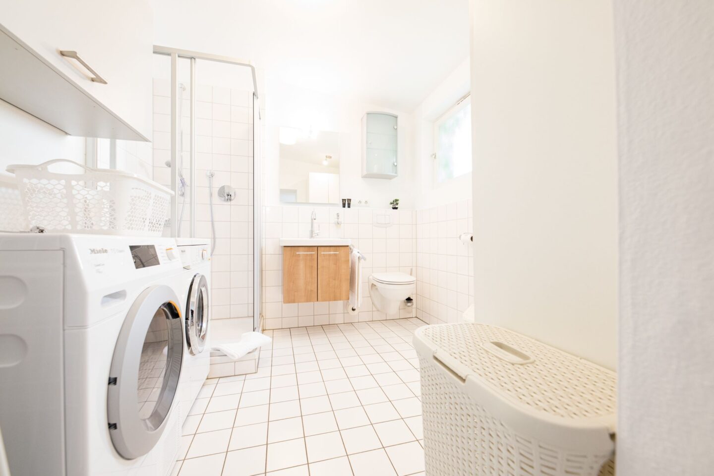 Badezimmer mit weißen Fliesen in Ferienwohnung in Garmisch-Partenkirchen