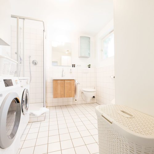 Badezimmer mit weißen Fliesen in Ferienwohnung in Garmisch-Partenkirchen