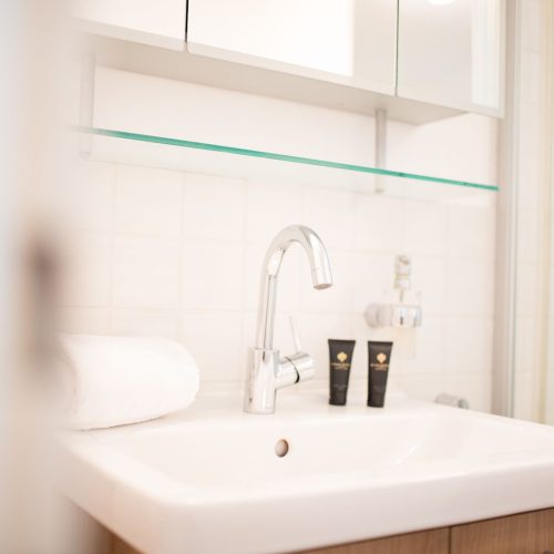 Badezimmer mit einem weißen Waschbecken in Ferienwohnung in Garmisch-Partenkirchen