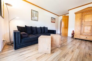 Wohnzimmer mit einem schwarzen Sofa  in Ferienwohnung in Garmisch-Partenkirchen