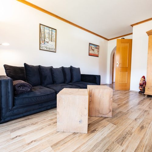 Wohnzimmer mit einem schwarzen Sofa in Ferienwohnung in Garmisch-Partenkirchen