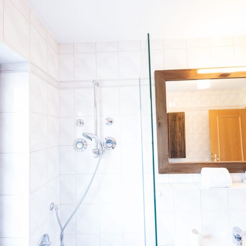 Badezimmer mit weißen Fliesen in Ferienwohnung in Garmisch-Partenkirchen