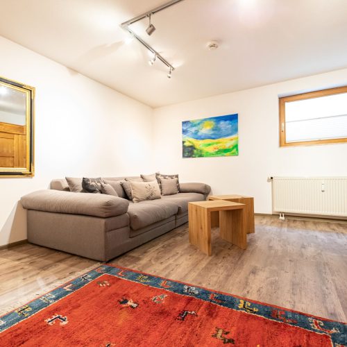 Wohnzimmer mit rotem Teppich in Ferienwohnung in Garmisch-Partenkirchen