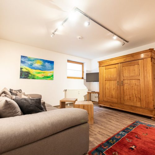 Wohnbereich mit einer grauen Couch in Ferienwohnung in Garmisch-Partenkirchen
