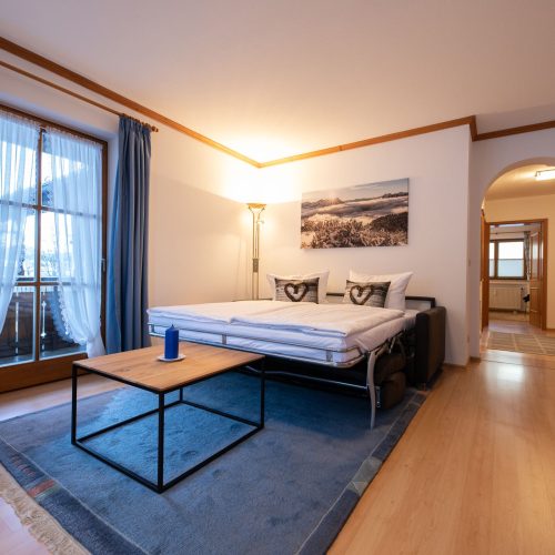 Wohnzimmer mit einem Schlafsofa in Ferienwohnung in Garmisch-Partenkirchen