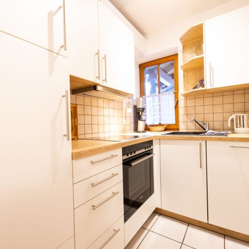 Küche mit weißen Schränken in Ferienwohnung in Garmisch-Partenkirchen