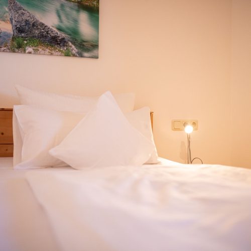 Schlafzimmer mit Bett und Nachtischlampe in Ferienwohnung in Garmisch-Partenkirchen