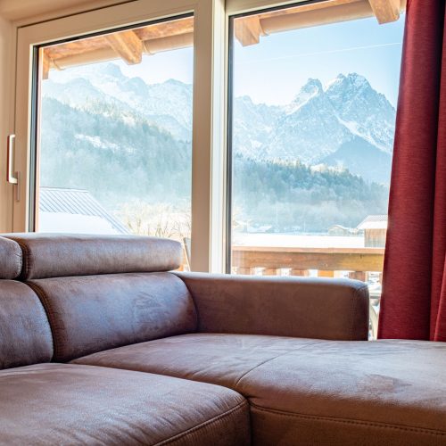Sofa mit Ausblick auf die Alpen in Ferienwohnung in Garmisch-Partenkirchen