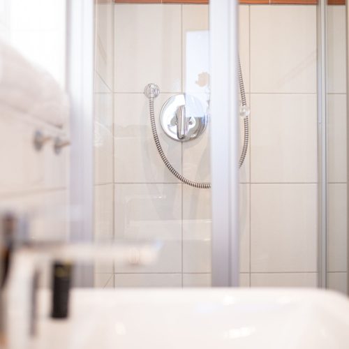 Badezimmer mit weißen Fliesen in Ferienwohnung in Garmisch-Partenkirchen