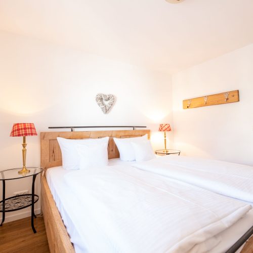 Schlafzimmer mit weißen Wänden in Ferienwohnung in Garmisch-Partenkirchen