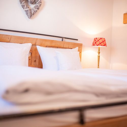 Schlafzimmer mit weißen Kissen in Ferienwohnung in Garmisch-Partenkirchen