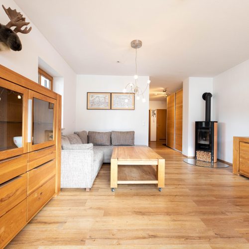 Wohnzimmer mit einer Kommode in einem warmen Holzton in Ferienwohnung in Garmisch-Partenkirchen