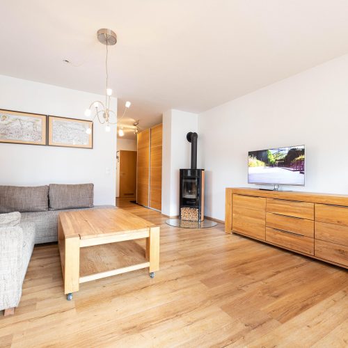 Wohnbereich mit einem Kamin und Fernseher in Ferienwohnung in Garmisch-Partenkirchen