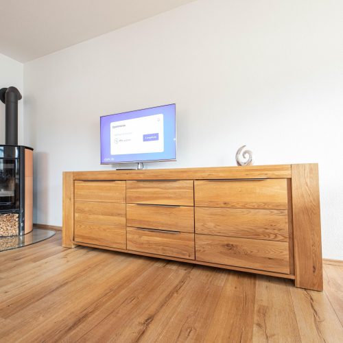 Holzschrank mit Fernseher und Holzkamin in Ferienwohnung in Garmisch-Partenkirchen