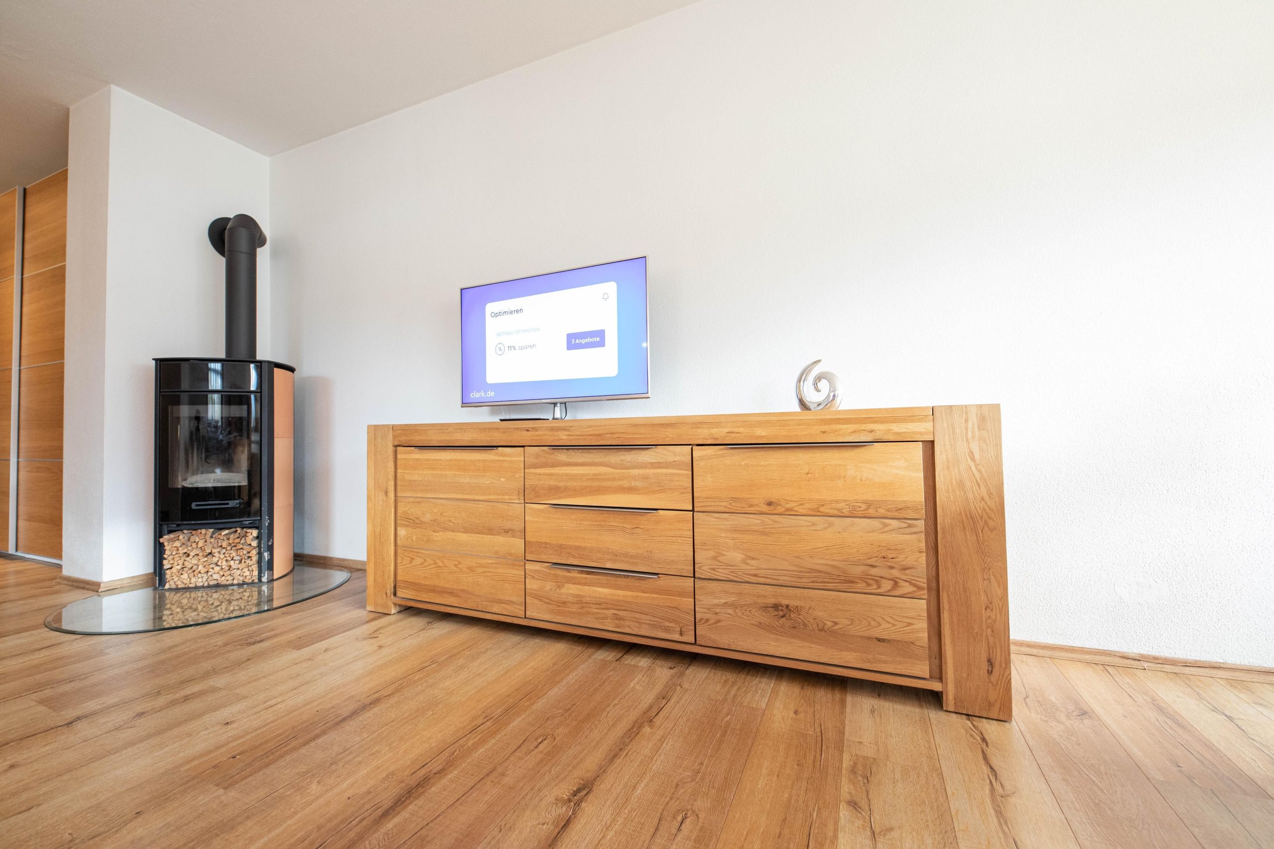Holzschrank mit Fernseher und Holzkamin in Ferienwohnung in Garmisch-Partenkirchen