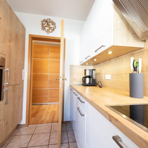 Küche mit Herd, Backofen und vielen Schränken in Ferienwohnung in Garmisch-Partenkirchen