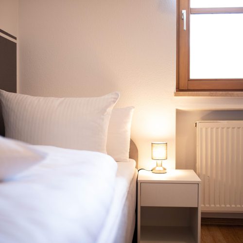 Einzelbett mit kleinem Nachttisch in Ferienwohnung in Garmisch-Partenkirchen