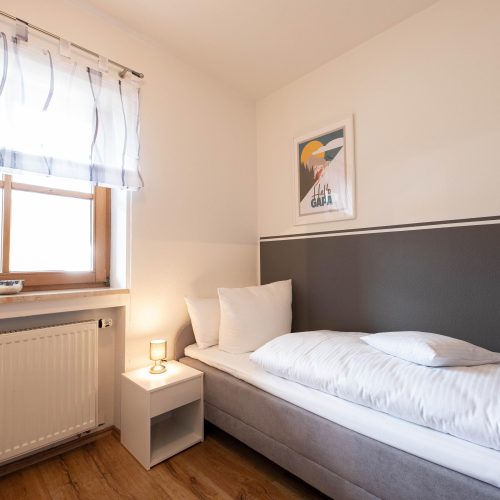 Einzelbett mit kleinem Bild in Ferienwohnung in Garmisch-Partenkirchen