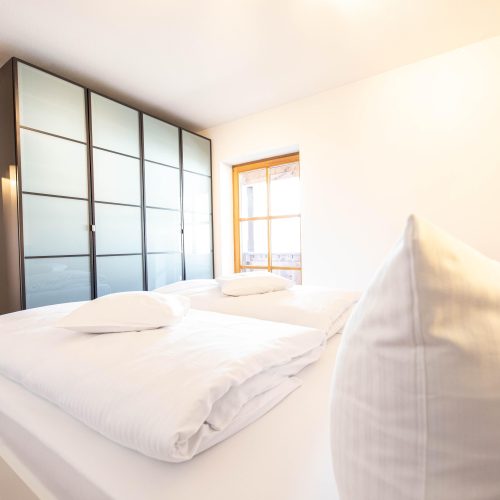 Weiches Boxspringbett mit hohem Wandschrank in Ferienwohnung in Garmisch-Partenkirchen