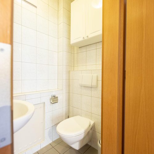 Kleines Badezimmer mit Holztür in Ferienwohnung in Garmisch-Partenkirchen