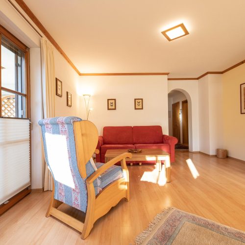 Wohnbereich mit einem blau gemusterten Sessel in Ferienwohnung in Garmisch-Partenkirchen