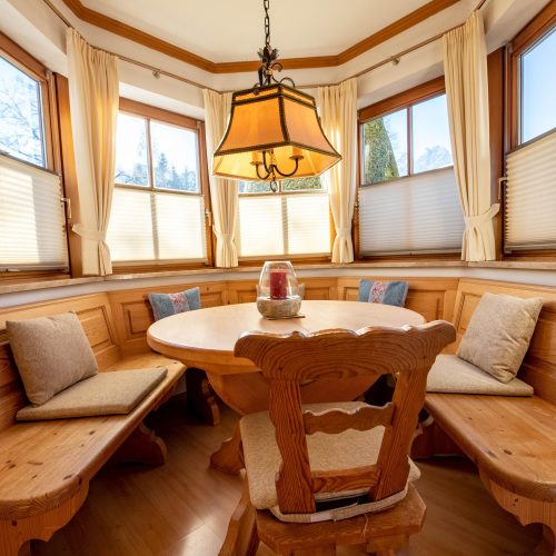 Sitzecke mit einem runden Tisch aus Holz in Ferienwohnung in Garmisch-Partenkirchen