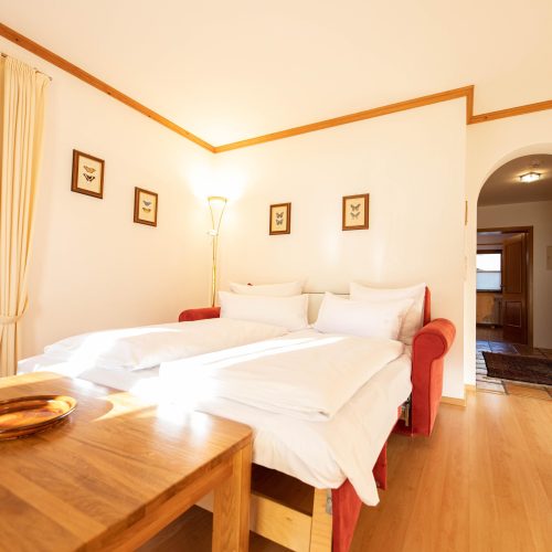 Schlafsofa mit einem Tisch in Ferienwohnung in Garmisch-Partenkirchen