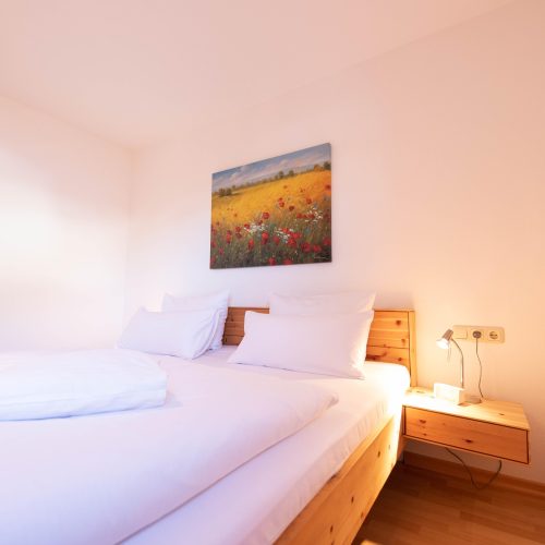 Schlafbereich mit Bildern von Blumen in Ferienwohnung in Garmisch-Partenkirchen