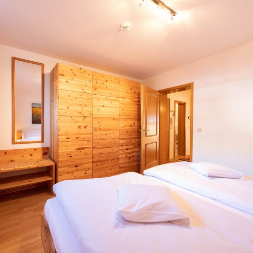 Schlafbereich mit einem Spiegel in Ferienwohnung in Garmisch-Partenkirchen
