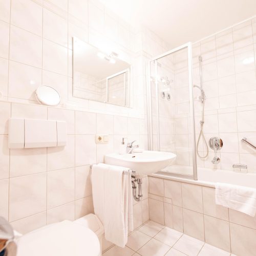 Badezimmer mit weißen Fliesen in Ferienwohnung in Garmisch-Partenkirchen