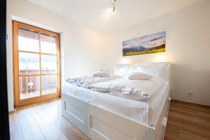 Hohes Boxspringbett mit weißem Bettkasten in Ferienwohnung in Garmisch-Partenkirchen