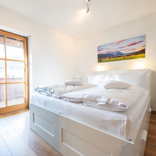 Hohes Boxspringbett mit weißem Bettkasten in Ferienwohnung in Garmisch-Partenkirchen