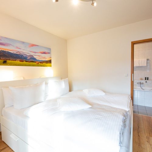 Schlafzimmer mit Zugang zum Badezimmer in Ferienwohnung in Garmisch-Partenkirchen