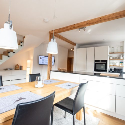 offene Küche mit grauer Wand in Ferienwohnung in Garmisch-Partenkirchen