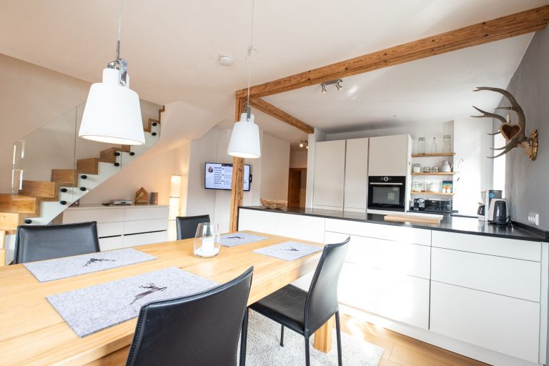 offene Küche mit grauer Wand in Ferienwohnung in Garmisch-Partenkirchen