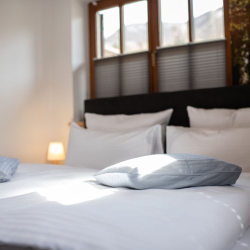 Schlafzimmer mit vielen Kissen und einem weichen Bett in Ferienwohnung in Garmisch-Partenkirchen