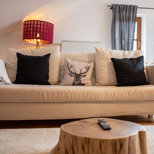 creme-farbenes Sofa mit Kissen in Ferienwohnung in Garmisch-Partenkirchen