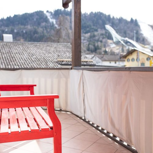 rote Bank auf dem Balkon in Ferienwohnung in Garmisch-Partenkirchen